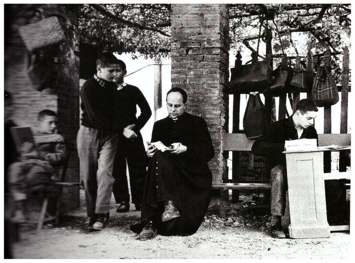 Barbiana, 1959. Don Lorenzo Milani insieme ai suoi studenti (Foto Oliviero Toscani da Wikimedia)