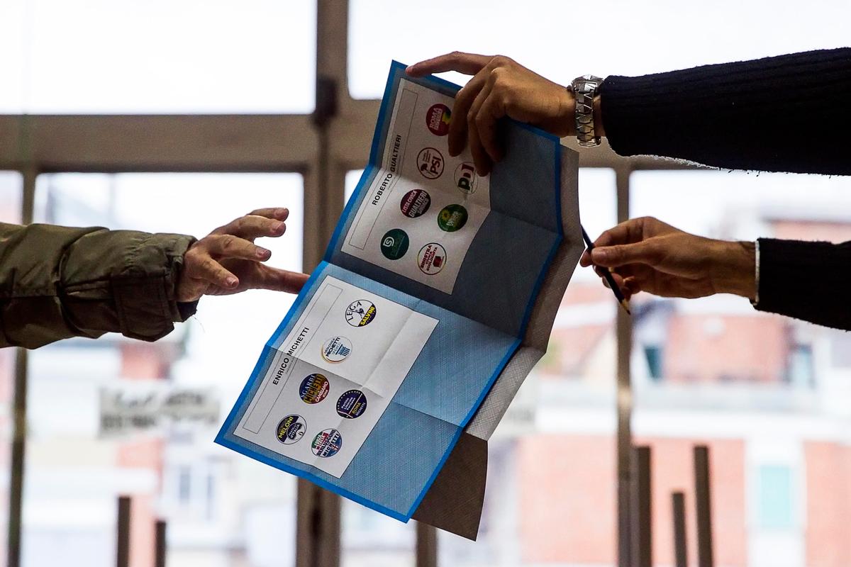 Un elettore prende la scheda elettorale per il ballottaggio delle amministrative a Roma (Carconi/Ansa)